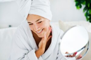 woman looking at her smooth skin after dermal filler treatment